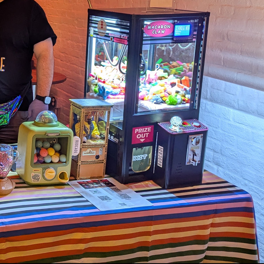 Budcade claw machine and tabletop prize games set up at an event