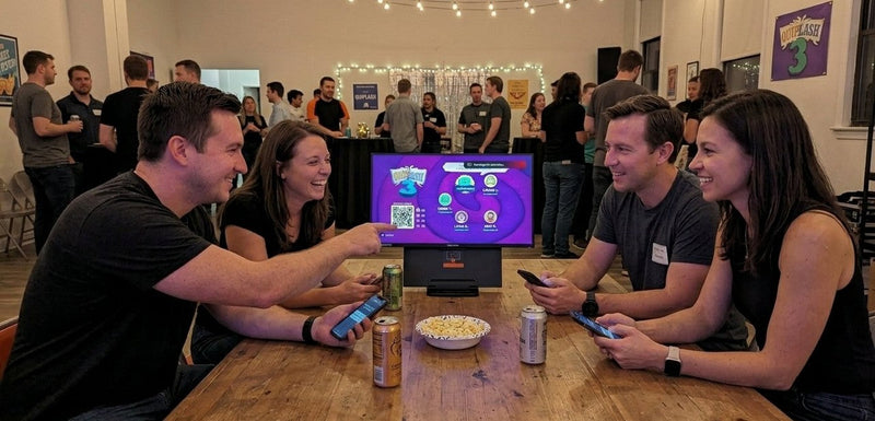 Example mobile party game setup: friends playing on their phones around one screen