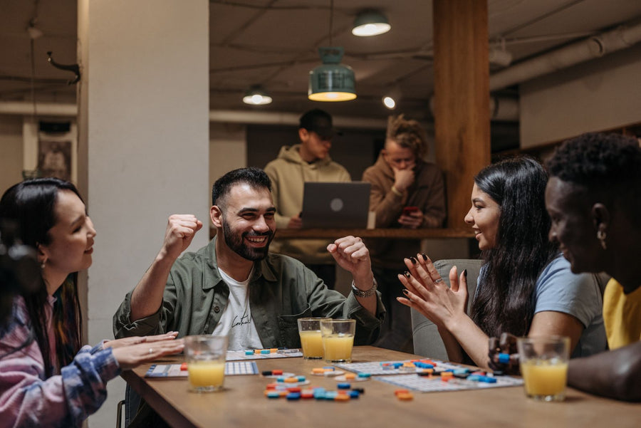 Friends laughing and cheering over a board game