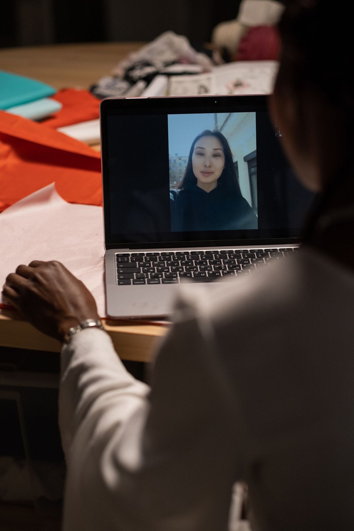 A woman on a video call with a colleague on her laptop
